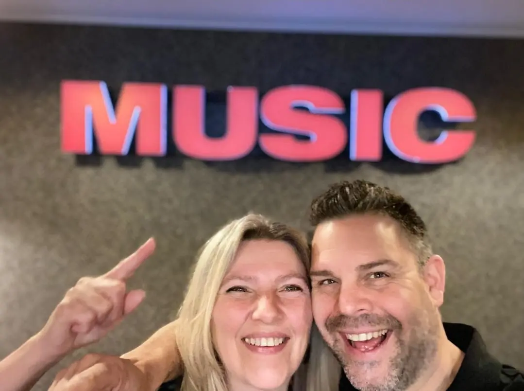 Patrick en Tamara in de winkel, onder een groot bord met het woord Music